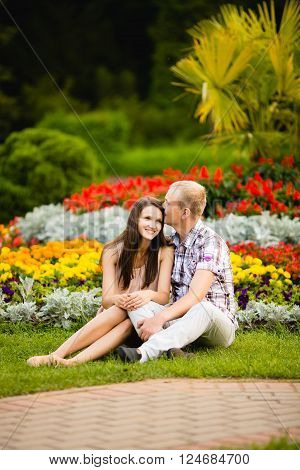 Cute teen couple lovely hugging in the garden flowers.