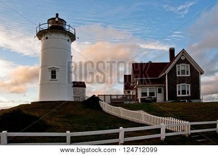 Sun sets behind Nobska lighthouse on Cape Cod, a popular tourist attraction.