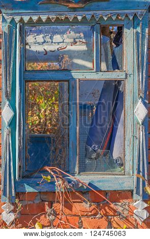 An old abandoned brick house with a broken window, closeup. As background for design of crisis.
