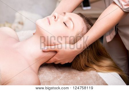 Blonde woman having facial massage in spa salon. close-up
