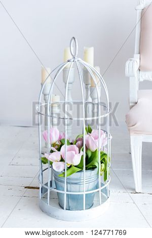 Tulips in an iron bucket. light background candles and flowers
** Note: Shallow depth of field