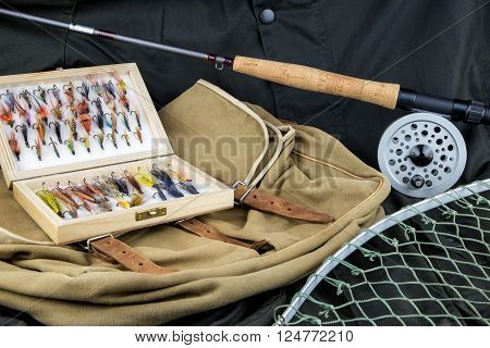 Fly fishing tackle with bag and net on outdoor coat