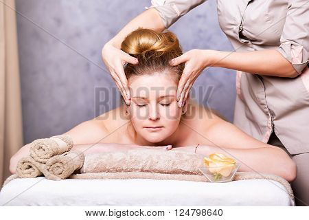 head Massage. Closeup of a Young Woman Getting Spa Treatment.