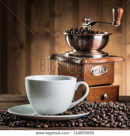 still life with coffee beans and old coffee mill on the wooden background 