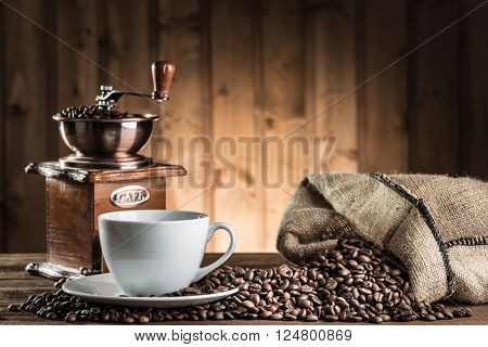 still life with coffee beans and old coffee mill on the wooden background 