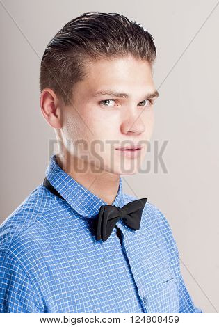 Profile of gallant man in the blue shirt with black bow tie.