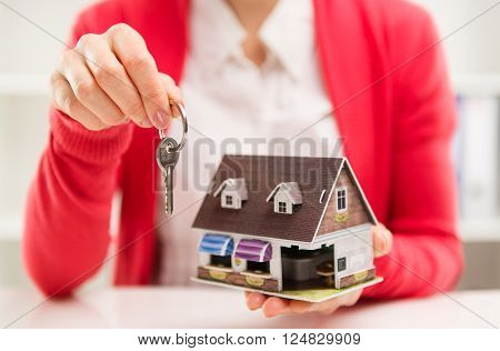 Real estate agent offering keys of new house to buyer