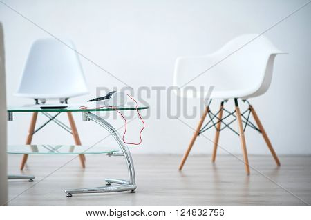 Contemporary design. View of light well designed room with white chairs and glass table