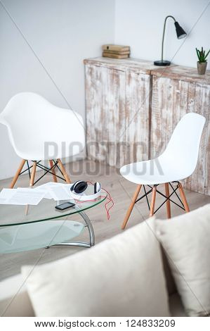 Cozy corner. View of white specious comfortable flat with chairs standing around glass table
