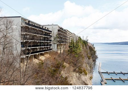Color DSLR image of apartment or condominium building on a cliff overlooking a lake.  Horizontal with copy space for text