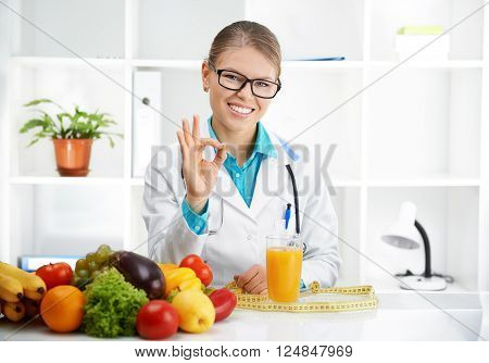 Happy smiling doctor dietitian showing 