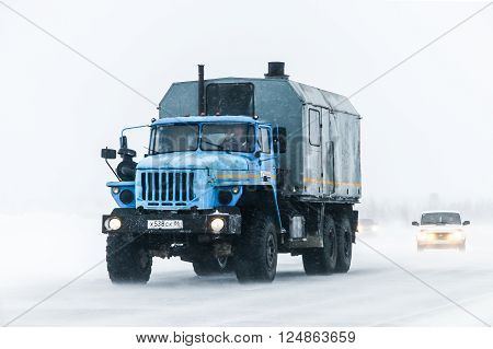 NOVYY URENGOY, RUSSIA - MARCH 20, 2016: Truck Ural 4320 at the interurban freeway during a heavy northern blizzard.