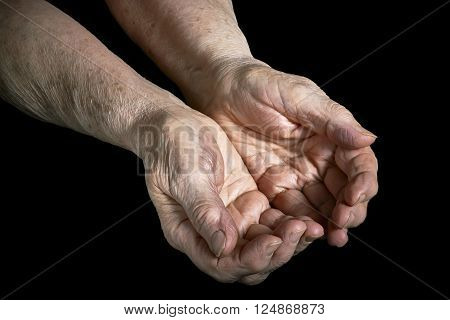 Senior woman hands open on a black background
