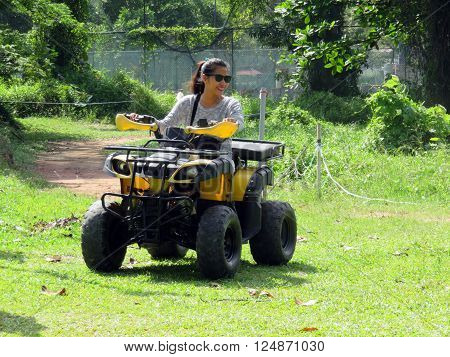 Young woman having fun riding ATV all-terrain vehicle