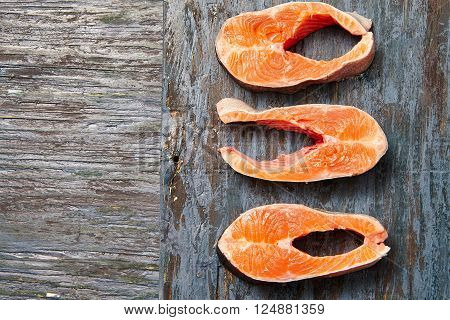 Raw salmon fillet on wood board space for text. Healthy food concept. Top view.