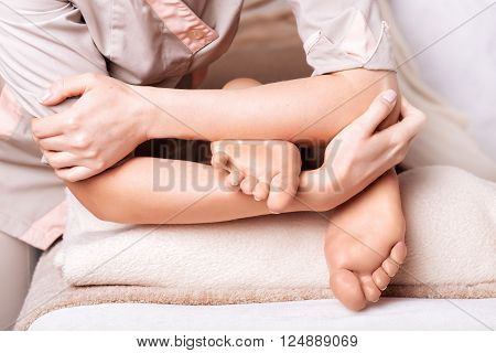 Woman having  therapeutic foot massage in spa salon, closeup