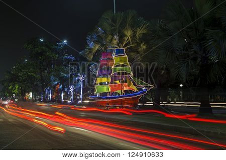 JAKARTA, INDONESIE - MARCH 16, 2016: Scale model sailboats illuminated by colored lights on a street in Jakarta. Ancol beach nearby. INDONESIA
