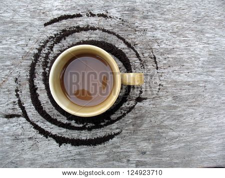 ground coffee with cup on wooden background