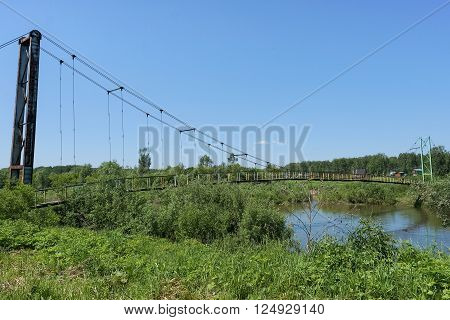 Hanging bridge and small river. Summer landscape