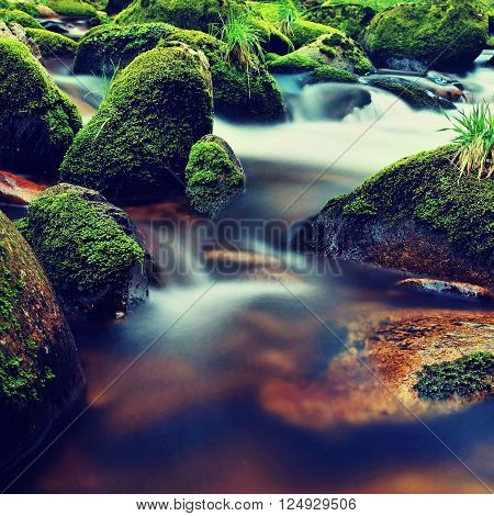 Mountain River With Blurred Waves Of Clear Water. White Curves In Rapids Between Mossy Boulders And