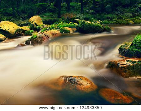 Mountain River With Blurred Waves Of Clear Water. White Curves In Rapids Between Mossy Boulders And