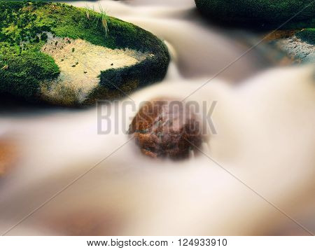 Mountain River With Blurred Waves Of Clear Water. White Curves In Rapids Between Mossy Boulders And