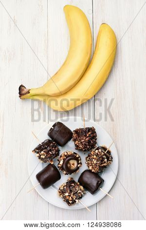 Frozen banana on wooden background top view