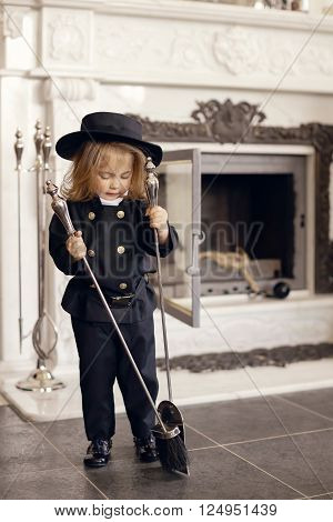 Girl as a chimney sweep against fireplace. Lucky New Year's Eve and New Year.