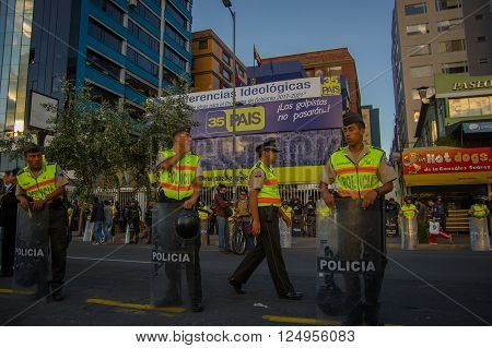 Quito, Ecuador - April 7, 2016: Police awaiting overlooking peaceful anti government protests in Shyris Avenue, beautiful blue sky and buildings background.