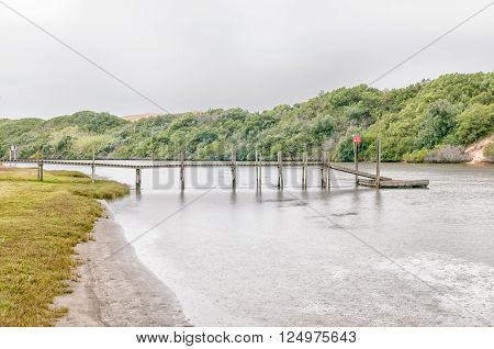 PORT ELIZABETH, SOUTH AFRICA - FEBRUARY 26, 2016: A pier in the Sundays River at Colchester in the Eastern Cape Province of South Africa. Falling rain is visible
