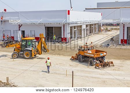 Plate compactor is mounted to the truck compacting soil for the new road construction site.