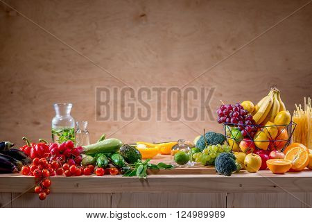 Table full of fruits and vegetables, drink and pasta with copy space on the wooden background
