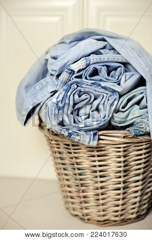 rolled jeans in a laundry basket on floor beige and blue combination