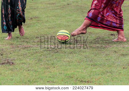 Labuan,Malaysia-Jan 18,2018:Group of man in traditional costume called sarongs playing traditional games village football in Labuan,Malaysia.A sarong or sarung is a large tube or length of fabric worn in Southeast Asia.