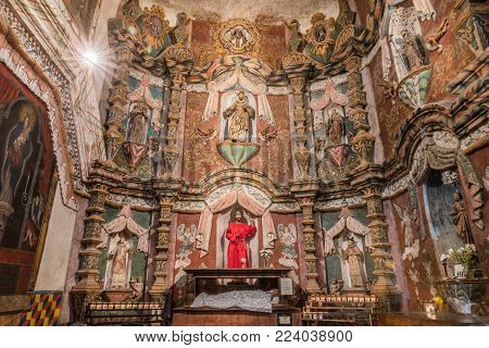 Tucson, Arizona, USA - January 9, 2018: West Transept reredos inside historic San Xavier Del Bac Mission. Many saint statues of which San Francisco is the main.