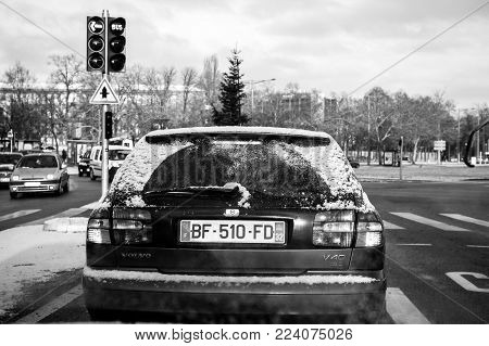 PARIS, FRANCE - JAN 16, 2017: Rear view of a Volvo V40 wagon car waiting at red light transporting in the trunk a fir tree for Christmas - getting ready for Christmas, buying fir tree