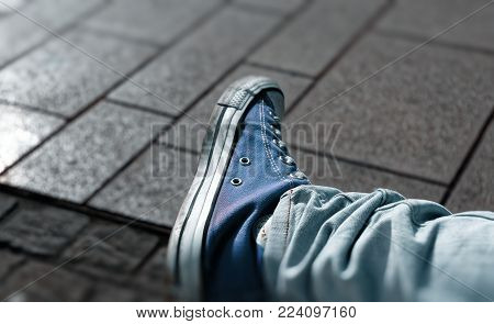 Sneaker shoes with blurred picture border and cobblestones in the background