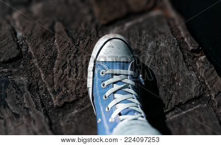 Sneaker shoes with blurred picture border and cobblestones in the background
