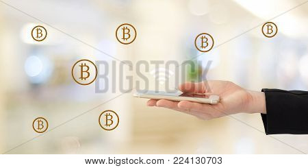 Blockchain concept, Gloden bitcoins icon over smart phone in businesswoman hand over blur background, financian business and technology