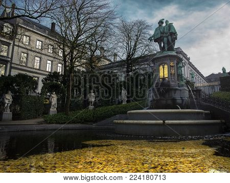 Brussels / Belgium - November 25th 2017: The small quiet Zavelsquare park in Brussels with the Statue of Counts Egmont and Hoorn on top of a fountain with the Egmont palace in the background.
