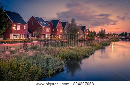 Long Exposure Night Shot Of Street With Modern Ecological Middle Class Family Houses With Eco Friend