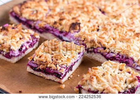 Homemade shortcrust fruit pie with crumble on a baking sheet - pastry with fruit or berry (cherry, plum, strawberry, raspberry) jam for tea time