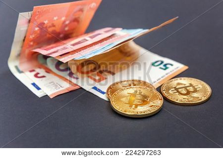 Physical version of Bitcoin, new virtual money . Golden symbolic coins of bitcoins on Euro banknotes. Exchange bitcoin. Concept worldwide cryptocurrency.