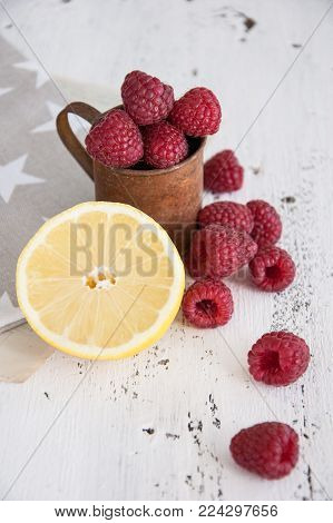 Fresh raspberry and lemon on a white wooden table