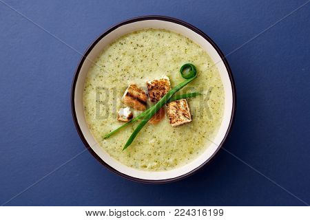 Vegan winter split pea turmeric soup on dark blue stone background. Top view, copy space.