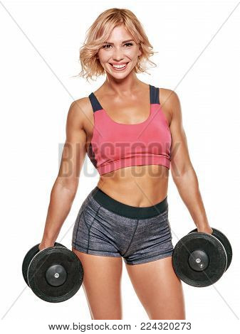 Portrait of athletic muscular cheerful woman exercising with dumbbells