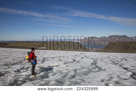 Longyearbean, Svalbard, Norway, July 18th, 2013: Hiker On A Glacier Above Small Town Of Longyearbean