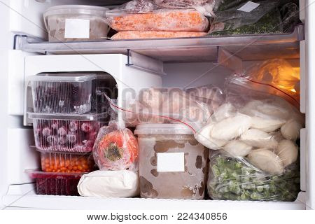 Assortment of frozen vegetables, meat and dumplings in home fridge
