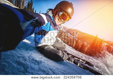 Selfie Guy sportsman goes on normal skiing on ski slope with action camera. Sunset. winter
