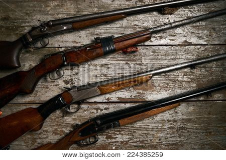 ollection of hunting rifles. Rifles, shotguns on wooden table background, Hunting guns close-up